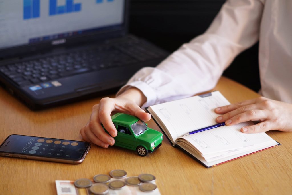 a professional calculating Subprime Auto Loan illustrating with a green toy car