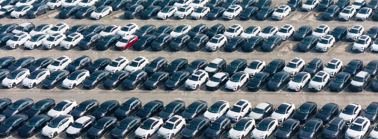 Aerial view of a large automotive lot packed with hundreds of used vehicles, illustrating used car market inventory in 2026