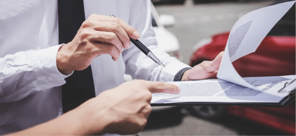 Insurance adjuster reviewing diminished value claim paperwork for a financed vehicle after an accident