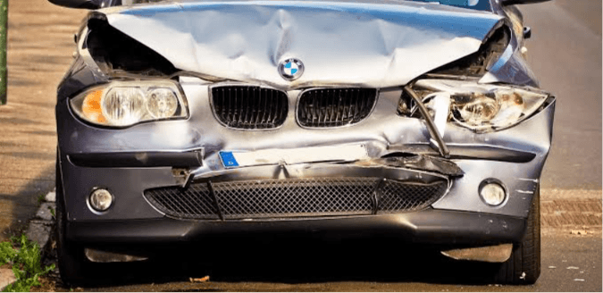 Silver luxury sedan with damaged front bumper and hood after a collision, illustrating diminished value