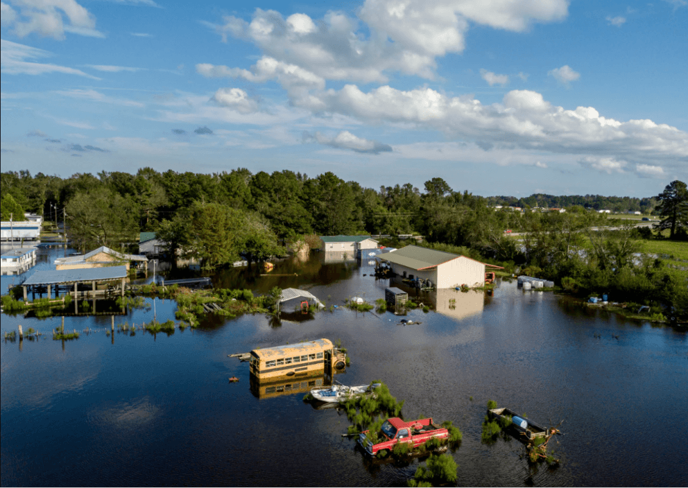 Truck and school bus partially submerged in floodwater after inland hurricane flooding in the Carolinas