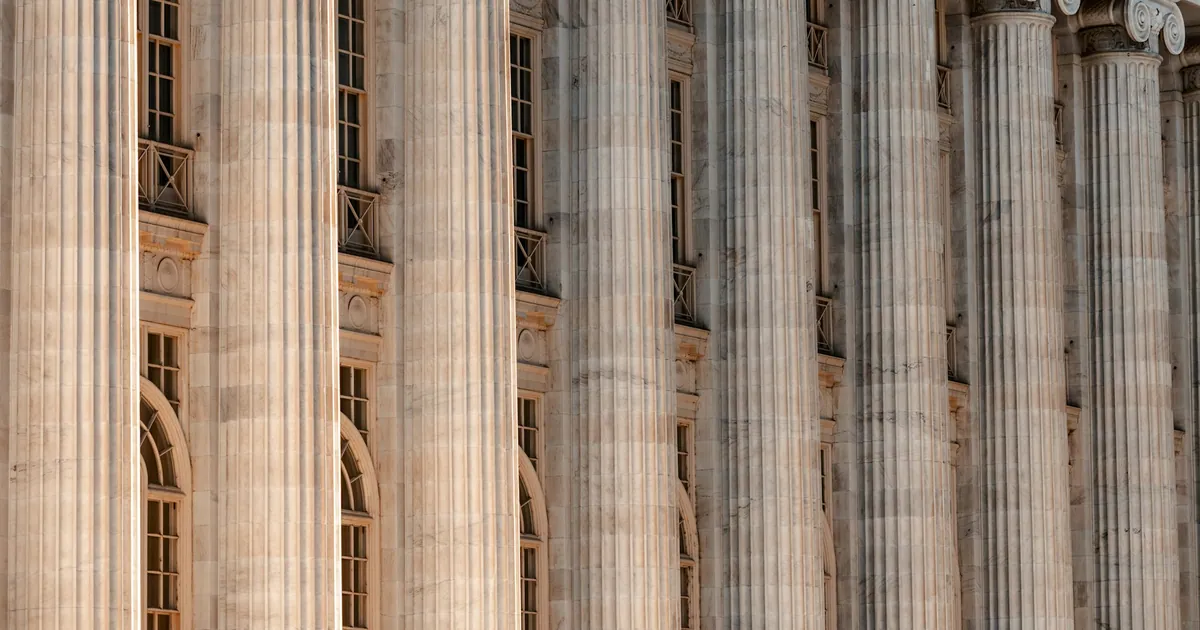 Row of tall fluted stone columns on the front of a classical public building